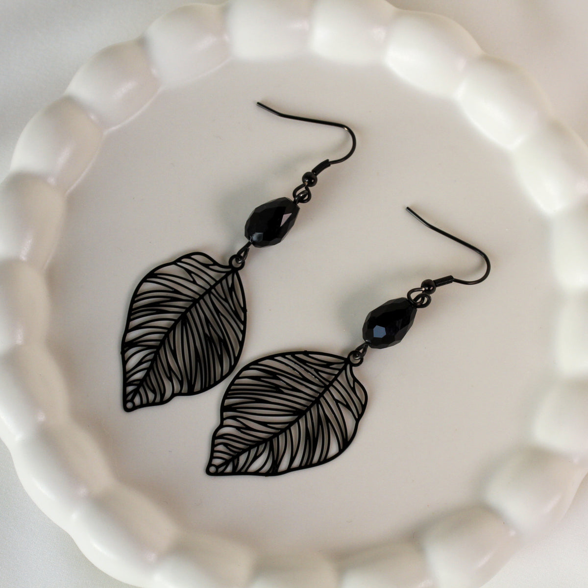 Nox Aveline – Schwarze Blatt-Ohrringe mit facettierter Perle