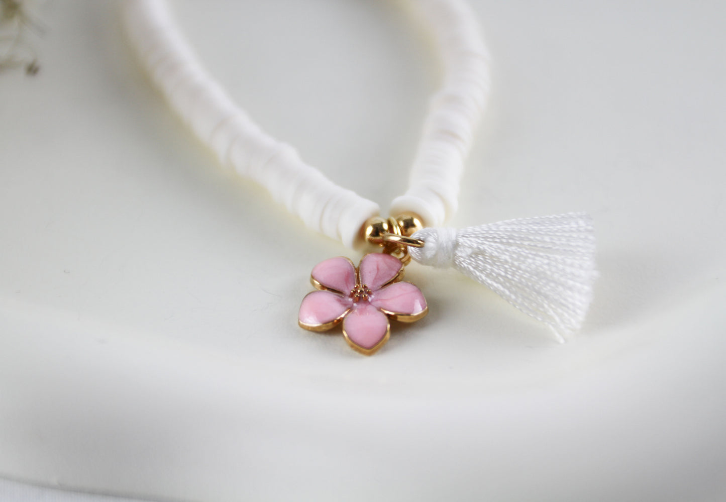 Weißes Katsuki Heishi Perlen Armband mit rosa Blumenanhänger und Quaste